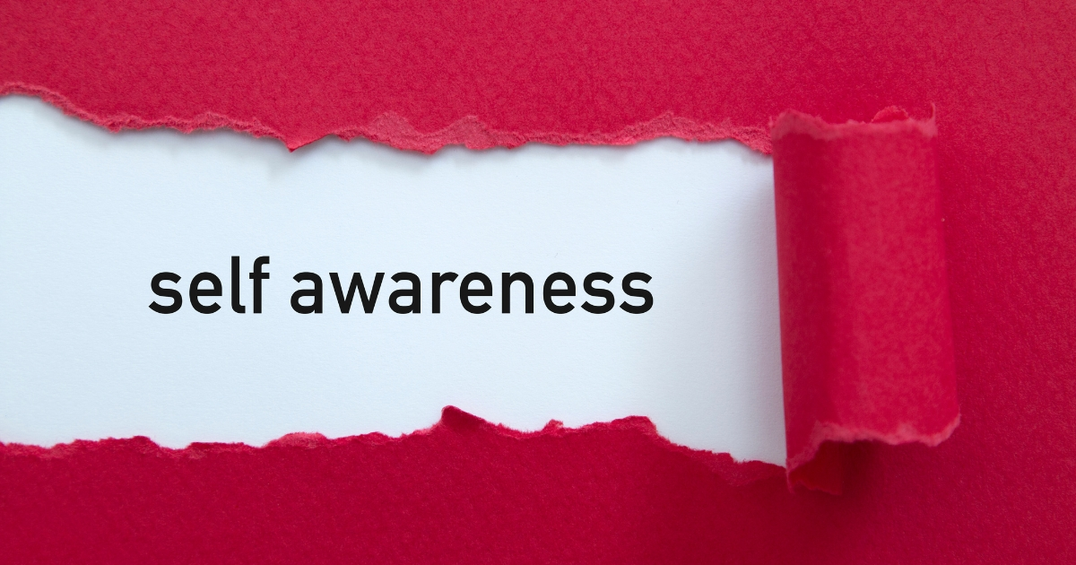 Torn red paper reveals a white card with the words self awareness in bold black font.”